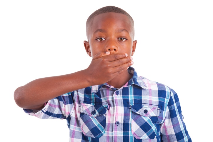 African American boy covering mouth