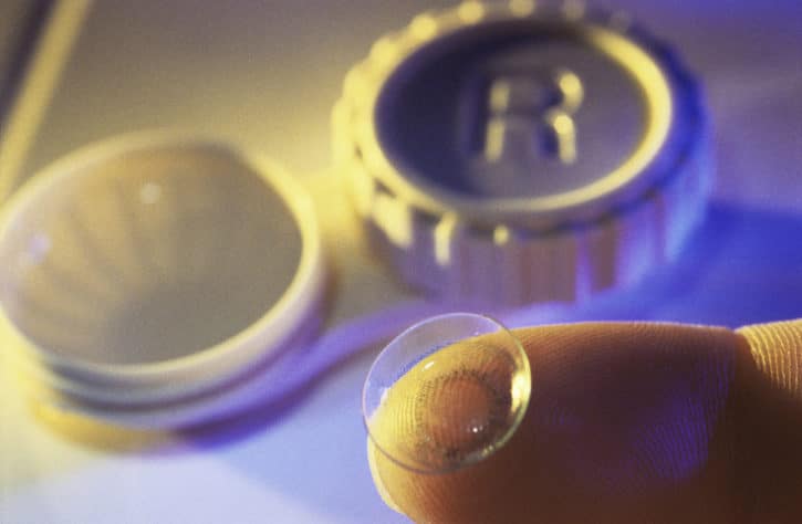 finger holding dirty contact lens