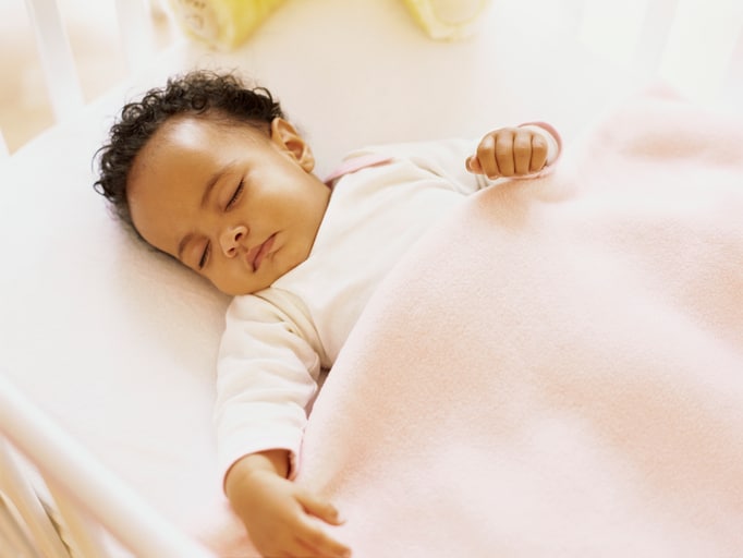 African American baby girl sleeping on back