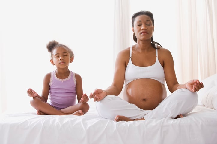 African American mother and daughter meditating