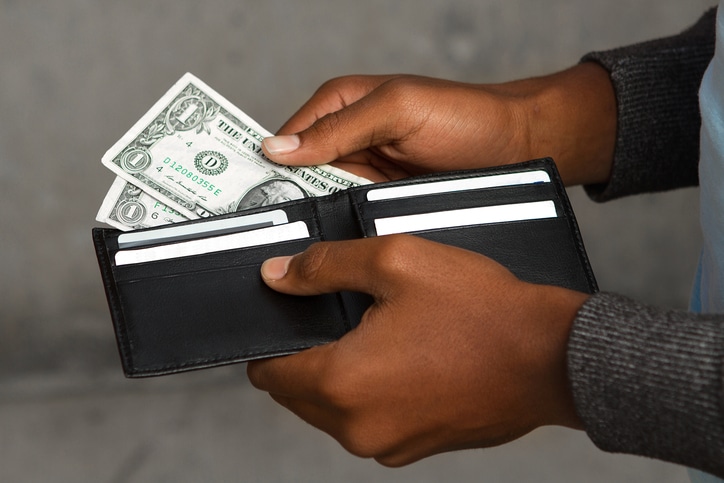 African American man pulling money out wallet