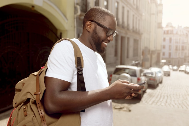 African American man smiling using cell phone