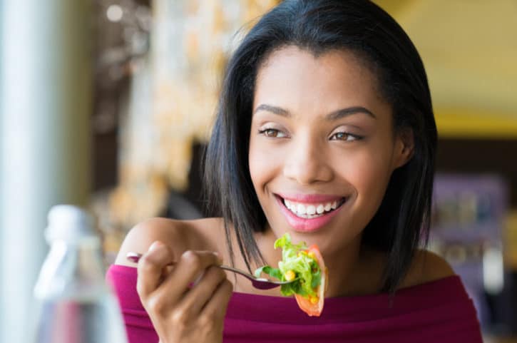 African American woman eating salad