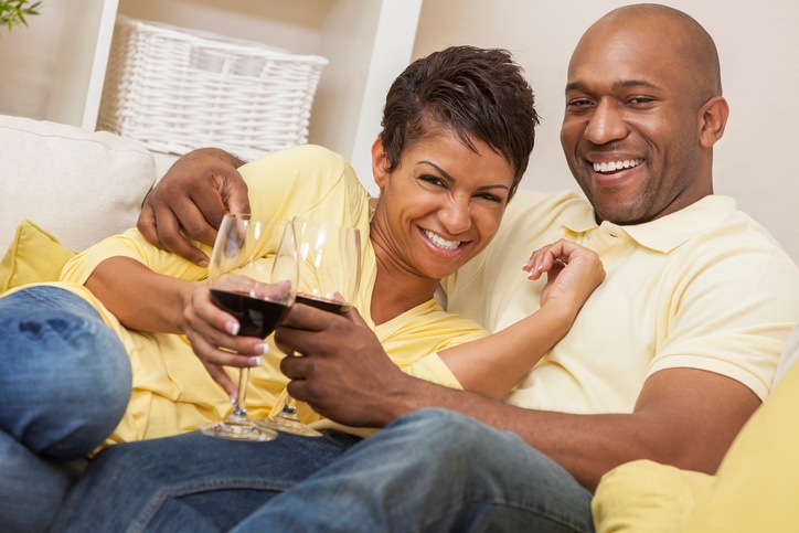 African American couple drinking wine on couch