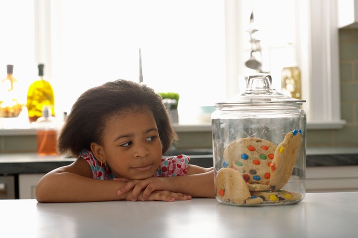 African American girl looking at cookie jar