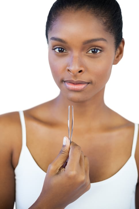 African American woman holding tweezers