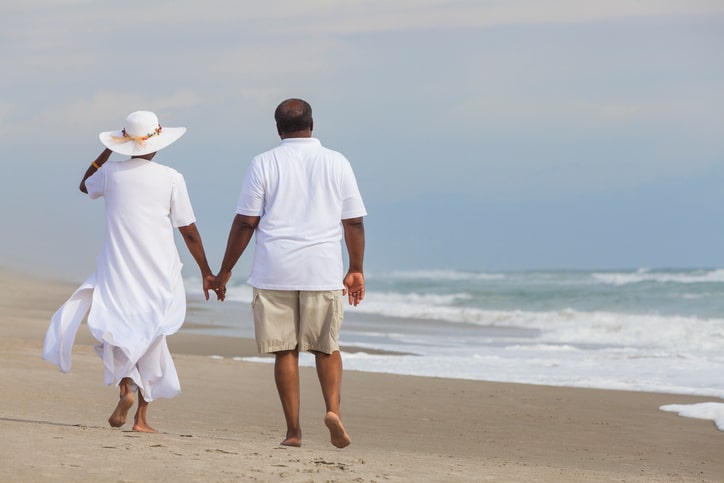 Senior African American couple walking on beach