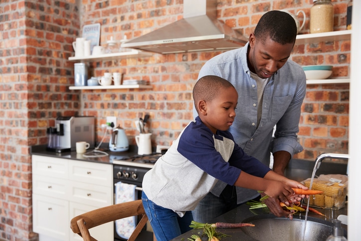African American father and son cooking