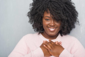 Woman holding chest. 