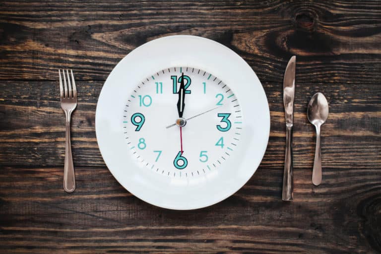 Twelve hour intermittent fasting time concept with clock on plate.