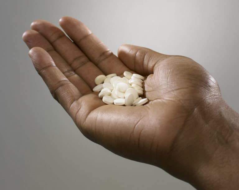 Person with a handful of pills